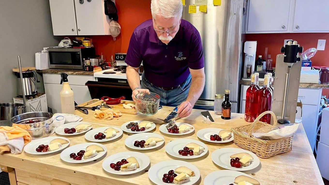 A man is preparing food on a table in a kitchen.