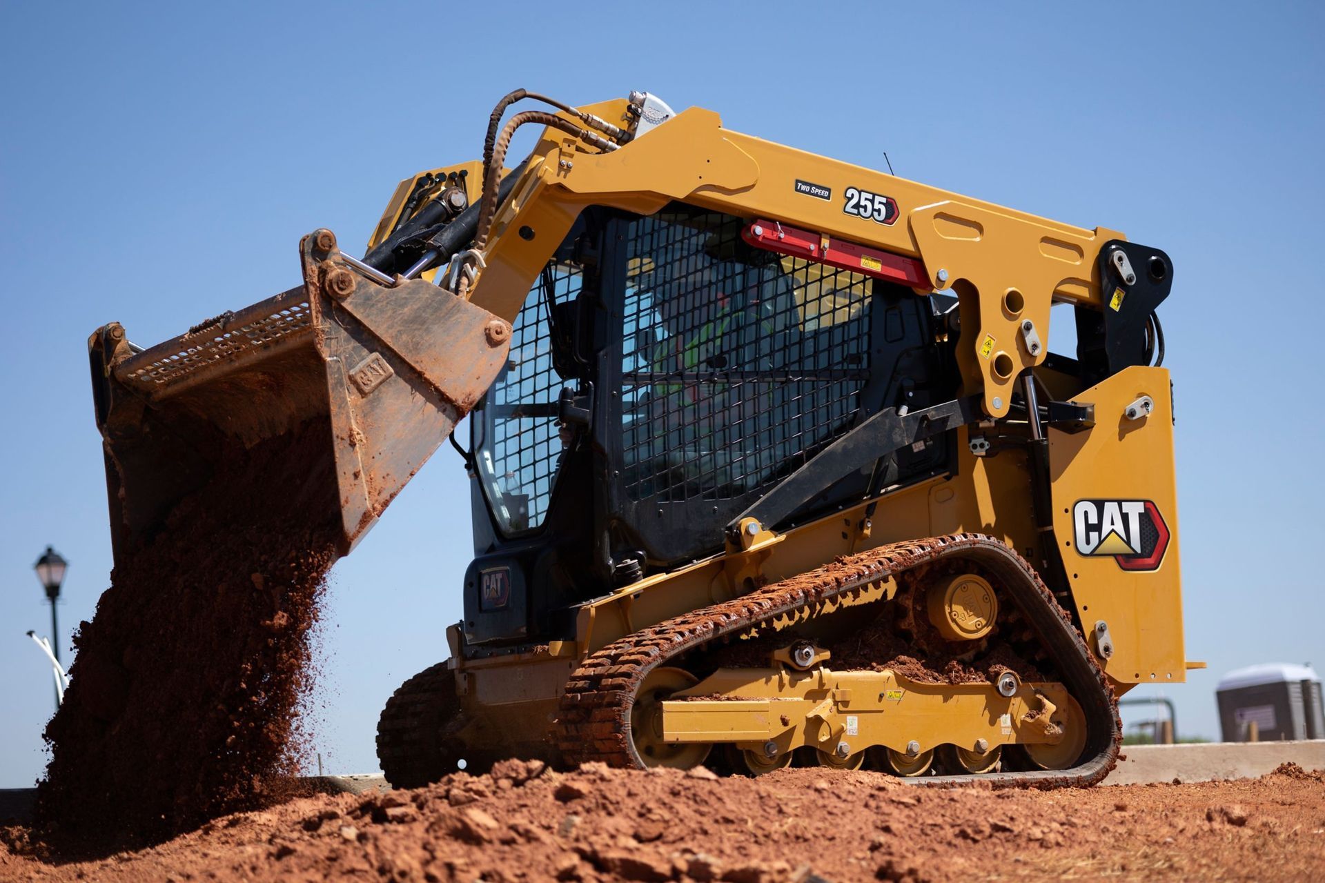 A yellow bulldozer is moving dirt in a field.