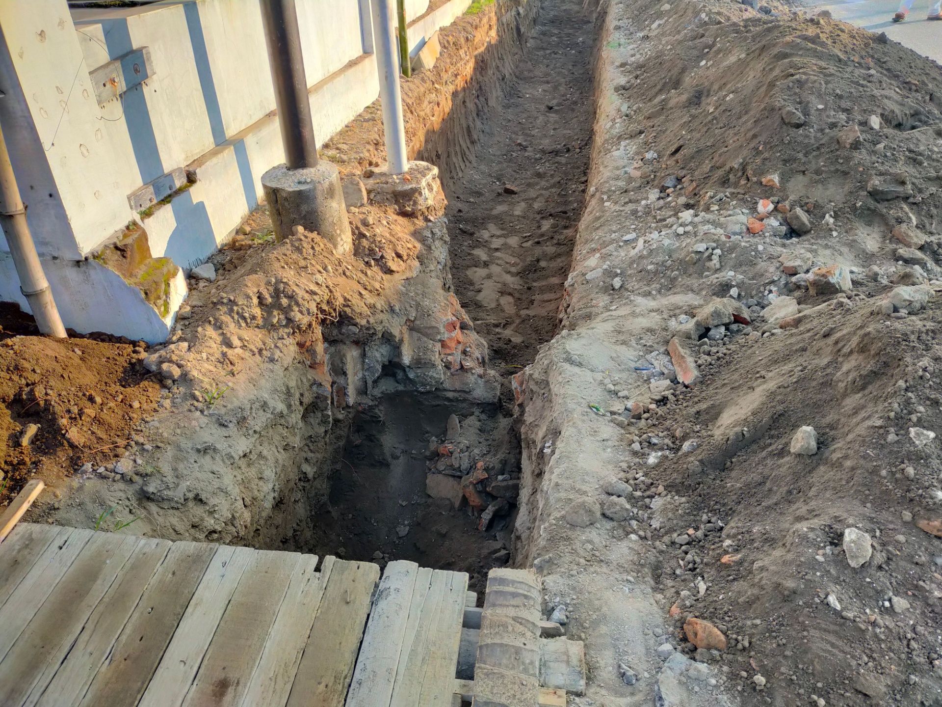A trench is being dug in front of a building.