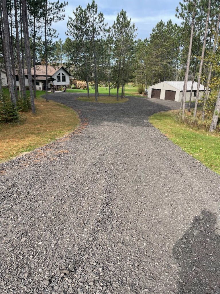 A man is paving a driveway in front of a house.