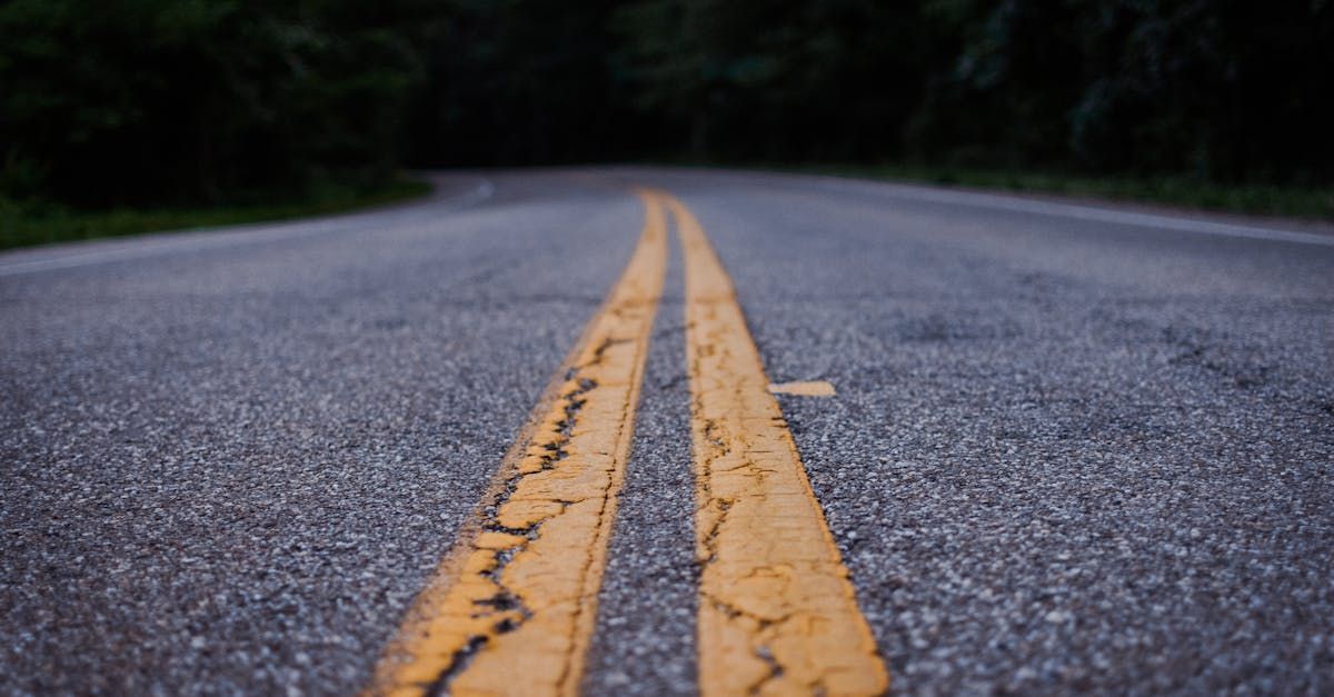 A close up of a road with two yellow lines on it.