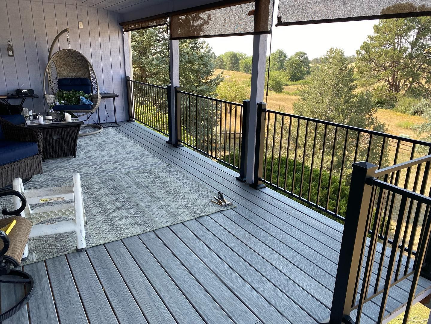 A porch with a view of a field and trees.