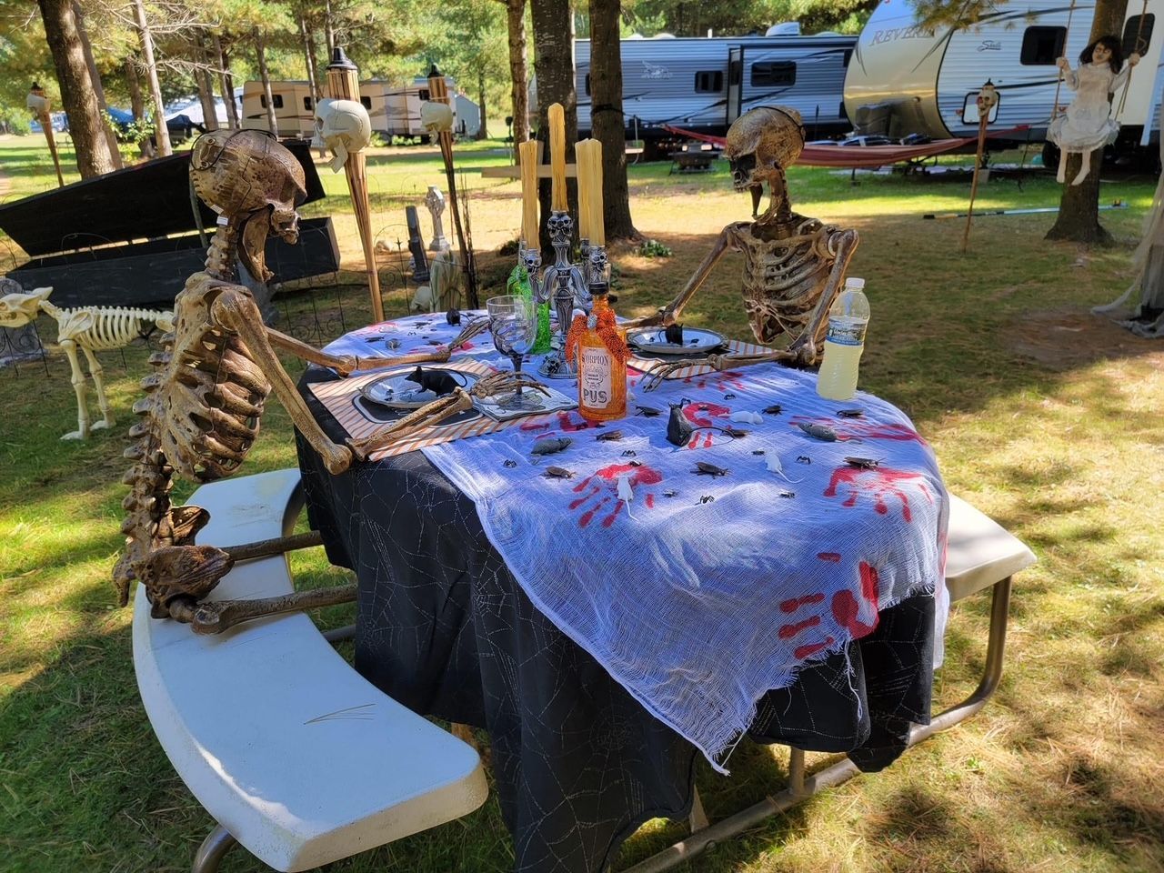 A table with skeletons on it is decorated for halloween.