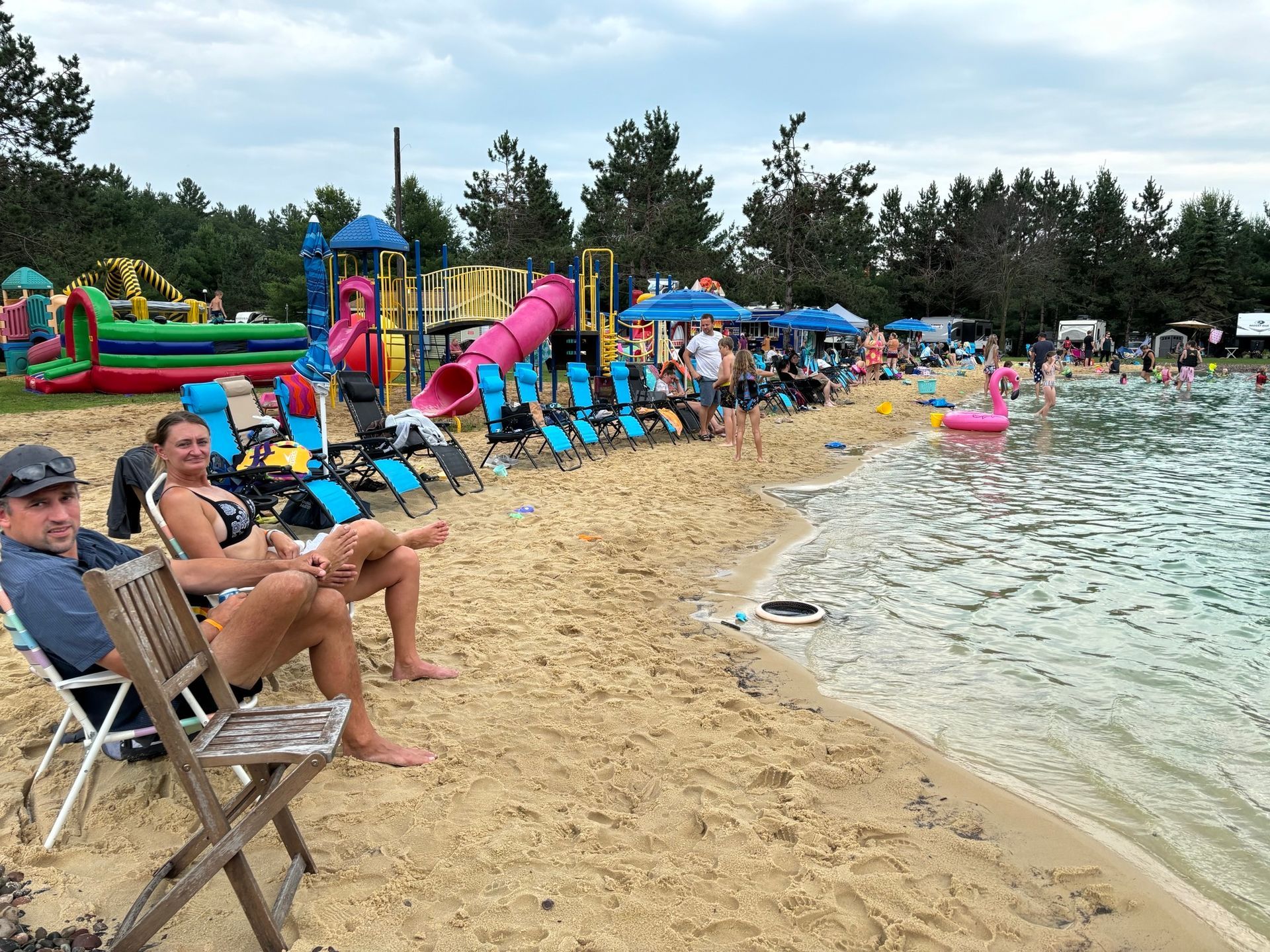 A group of people are sitting on the beach near the water.