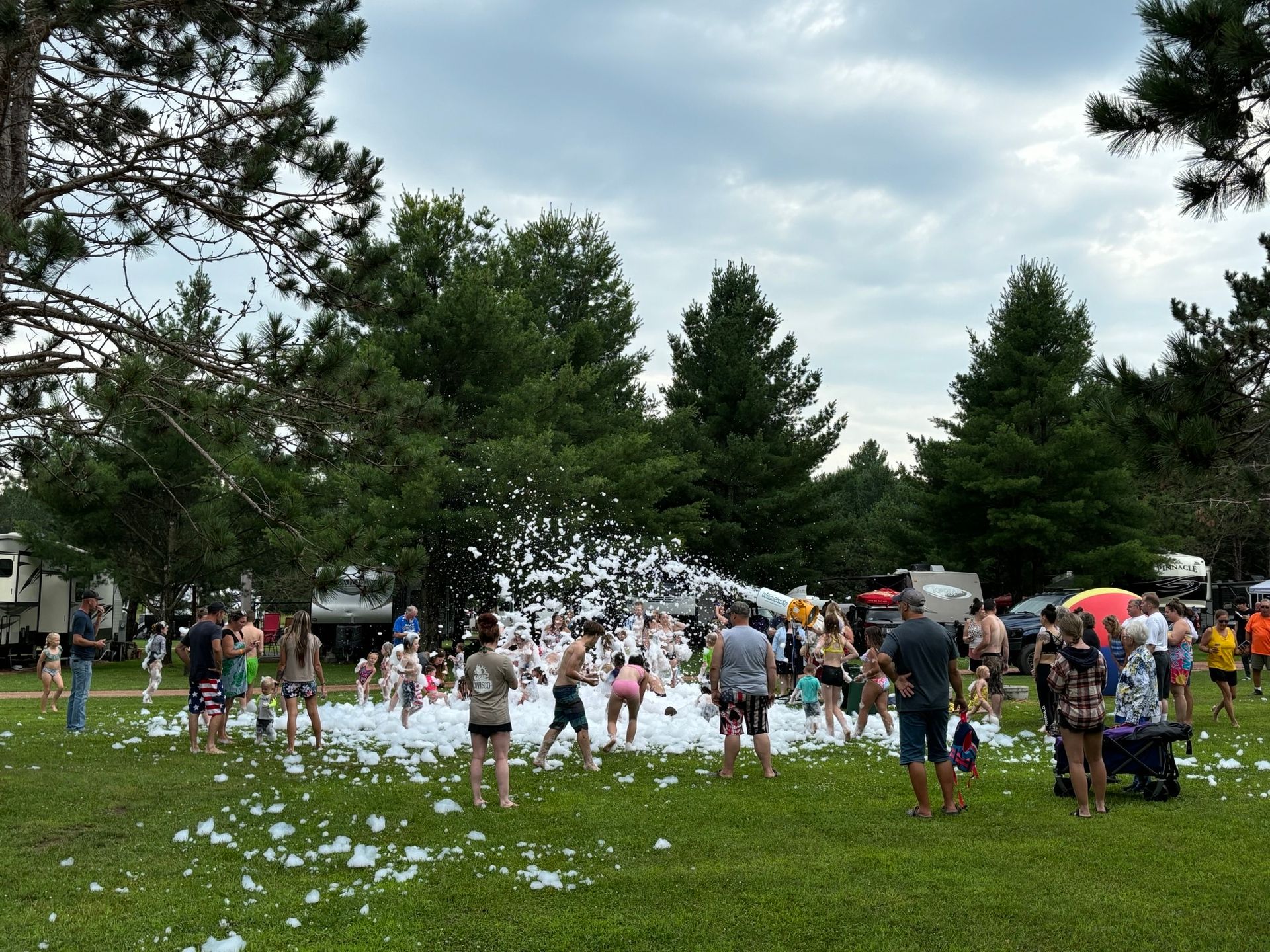 A group of people are playing with foam in a park.