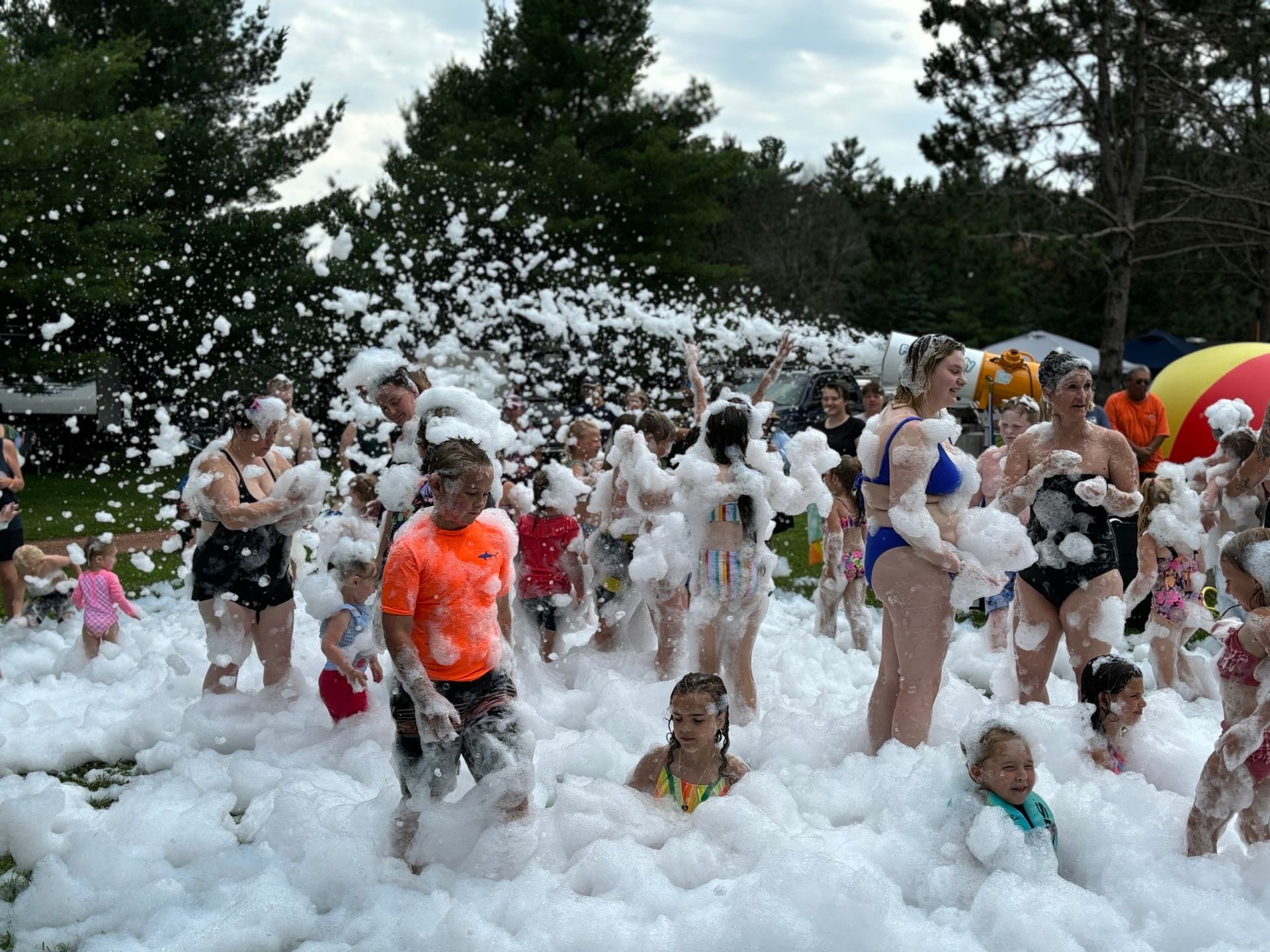 A group of people are playing in a pool of foam.