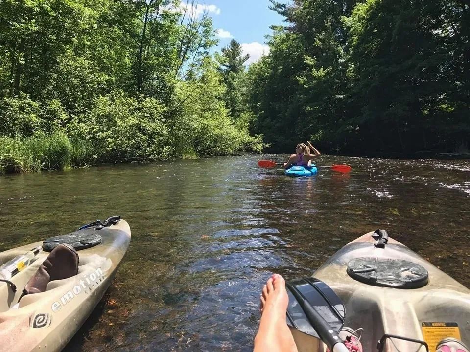 A person is sitting in a kayak on a river.
