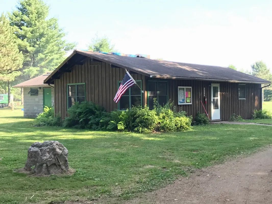 A wooden house with an american flag hanging from the roof.