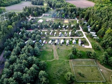 An aerial view of a campground surrounded by trees and grass.