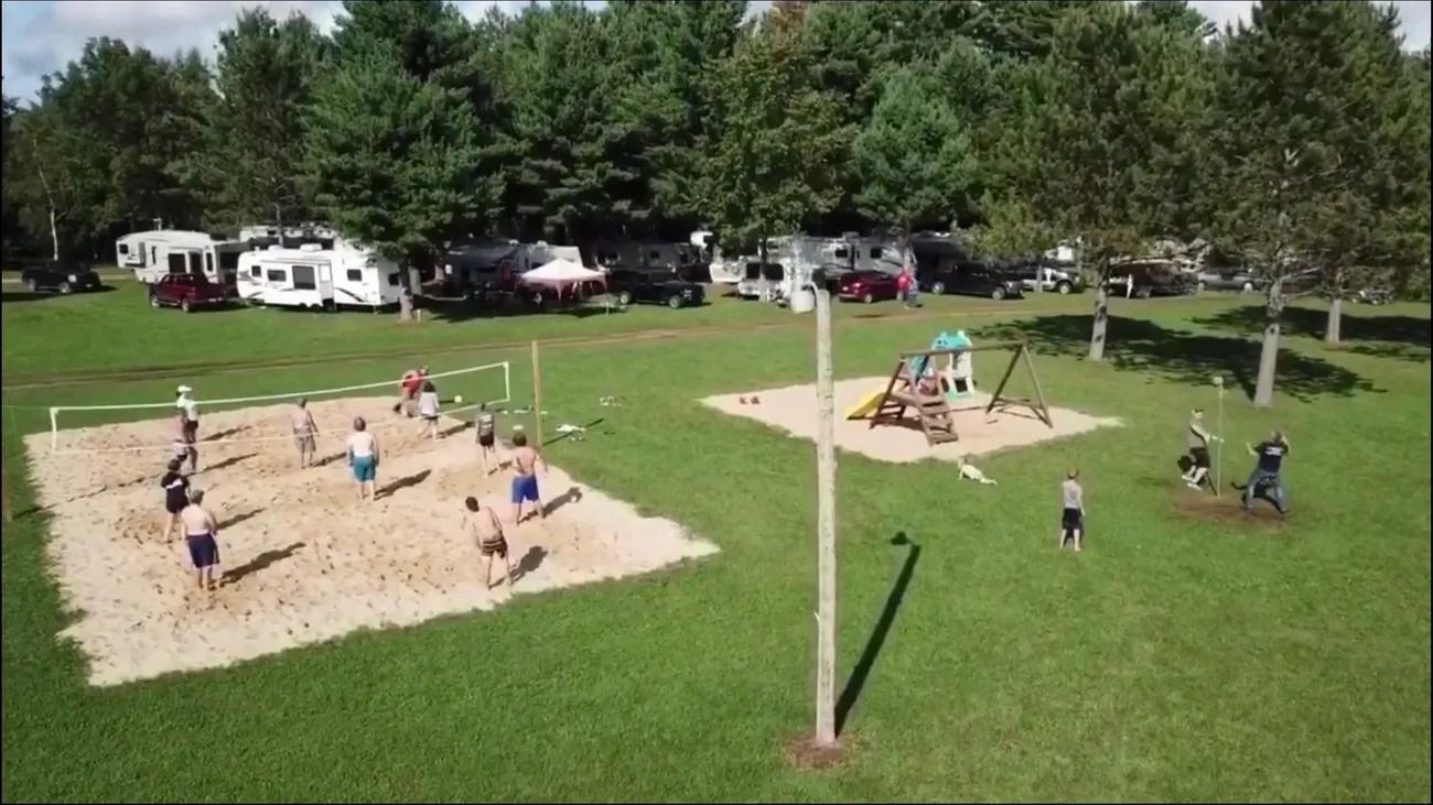 A group of people are playing volleyball in a park.