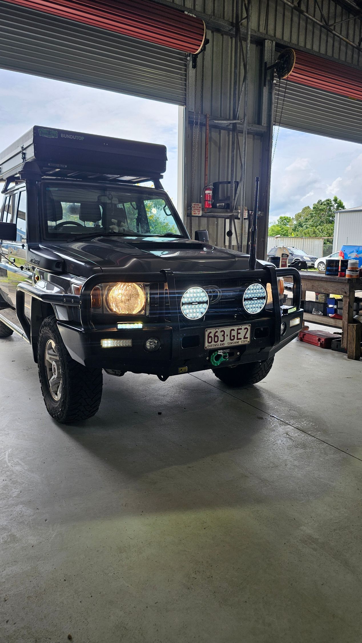 Black off-road vehicle with roof tent, in a garage, with work lights on — Track N Back 4x4 In Mareeba, QLD