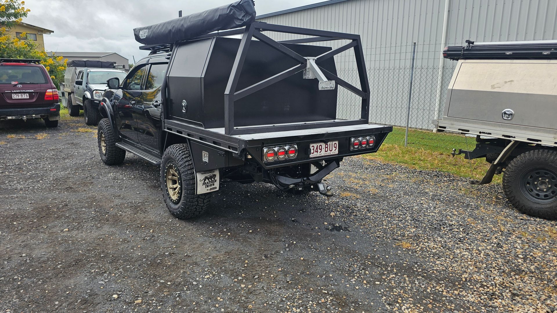 Black pickup truck with a custom cargo area and attached trailer parked outside — Track N Back 4x4 In Mareeba, QLD
