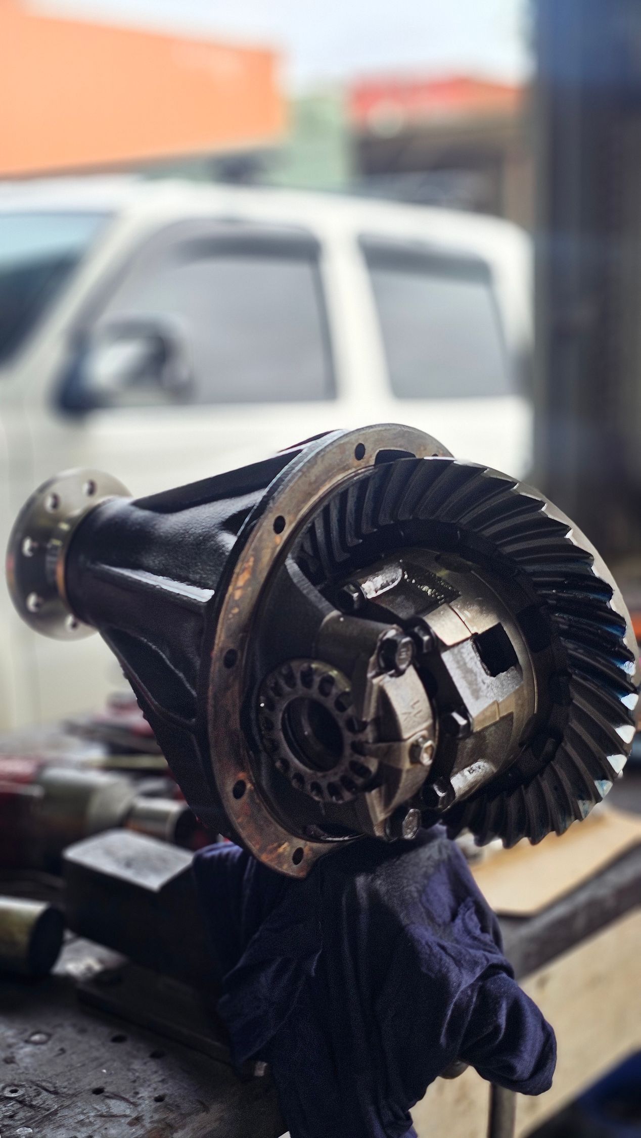 Black differential gear assembly on a workbench, with a blurry vehicle in the background — Track N Back 4x4 In Mareeba, QLD