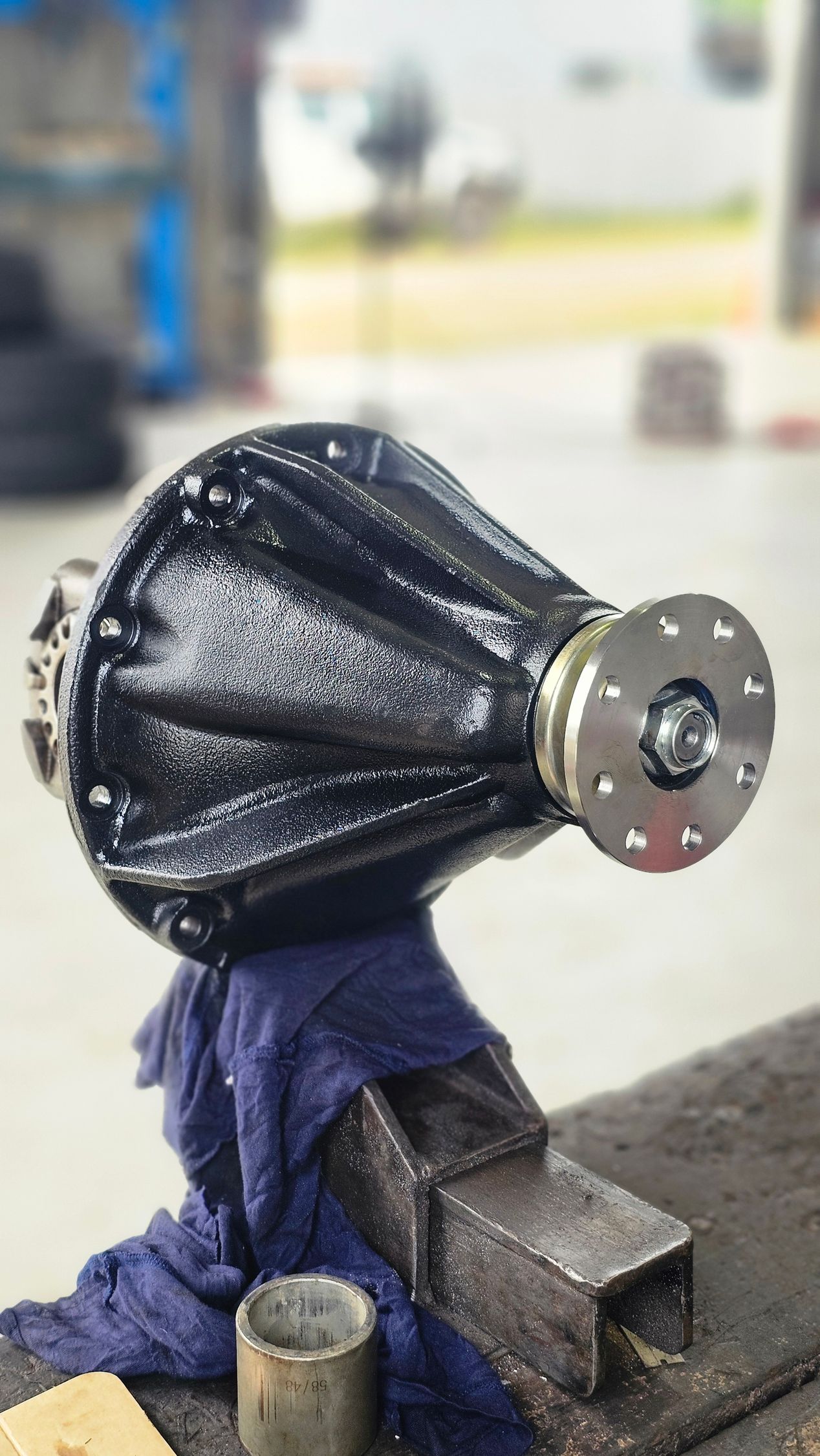 Black painted car differential clamped in a vice on a workbench with a blurry shop background — Track N Back 4x4 In Mareeba, QLD