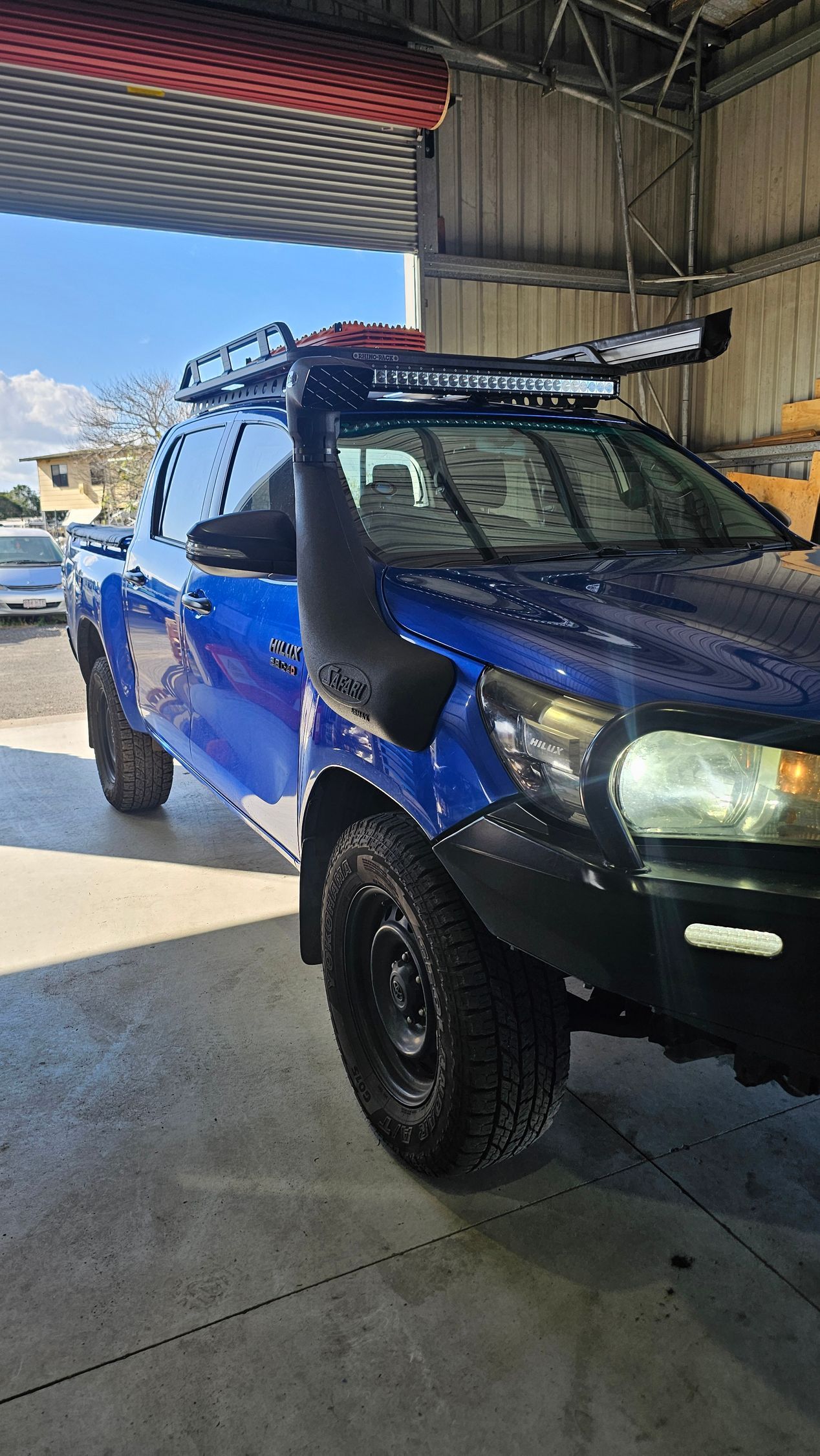 Blue off-road truck with snorkel and roof rack parked indoors, under fluorescent lighting — Track N Back 4x4 In Mareeba, QLD