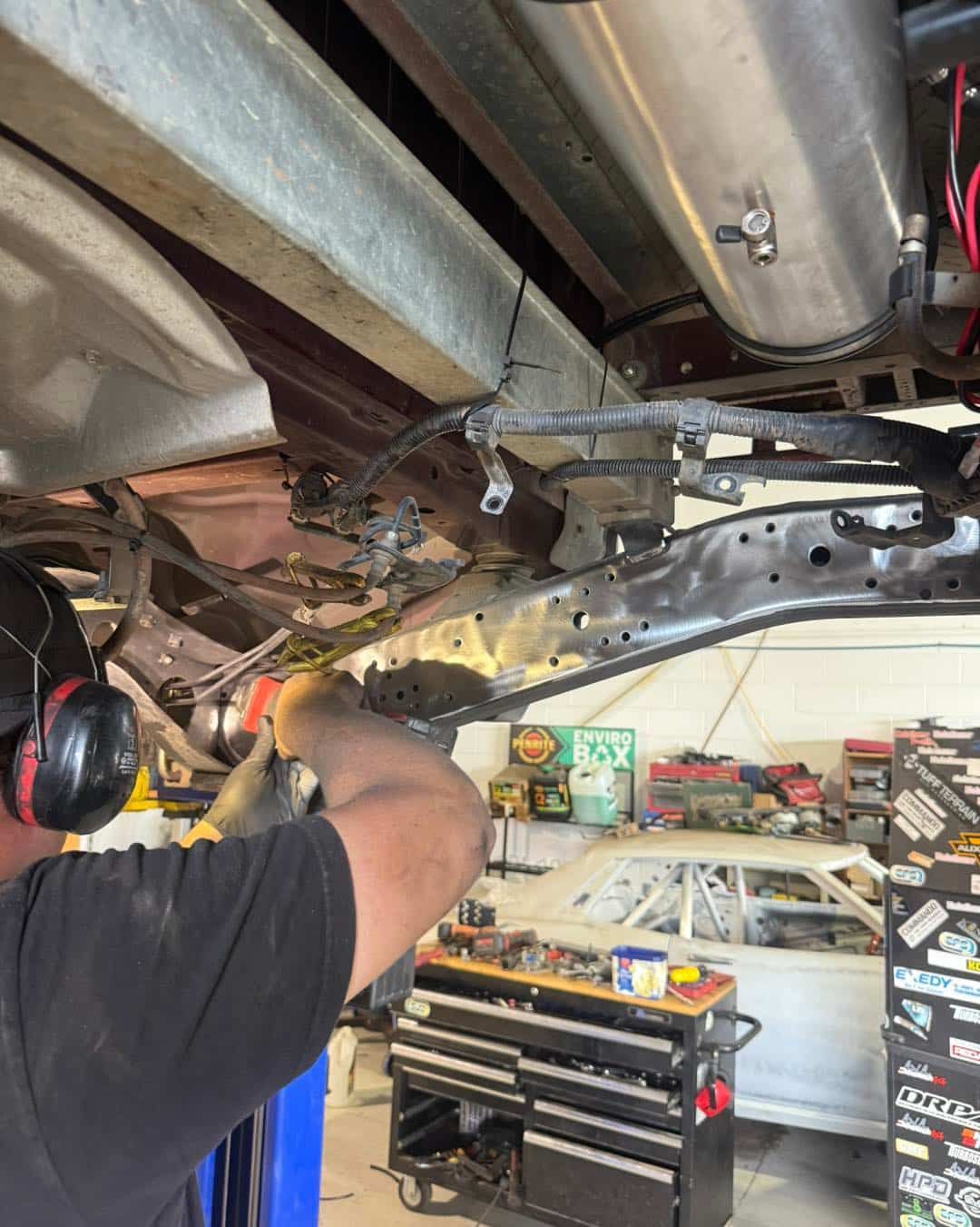 A Person Wearing Green Gloves Sprays Paint on a Silver Car Door With a Spray Gun — Track N Back 4x4 In Cooktown, QLD