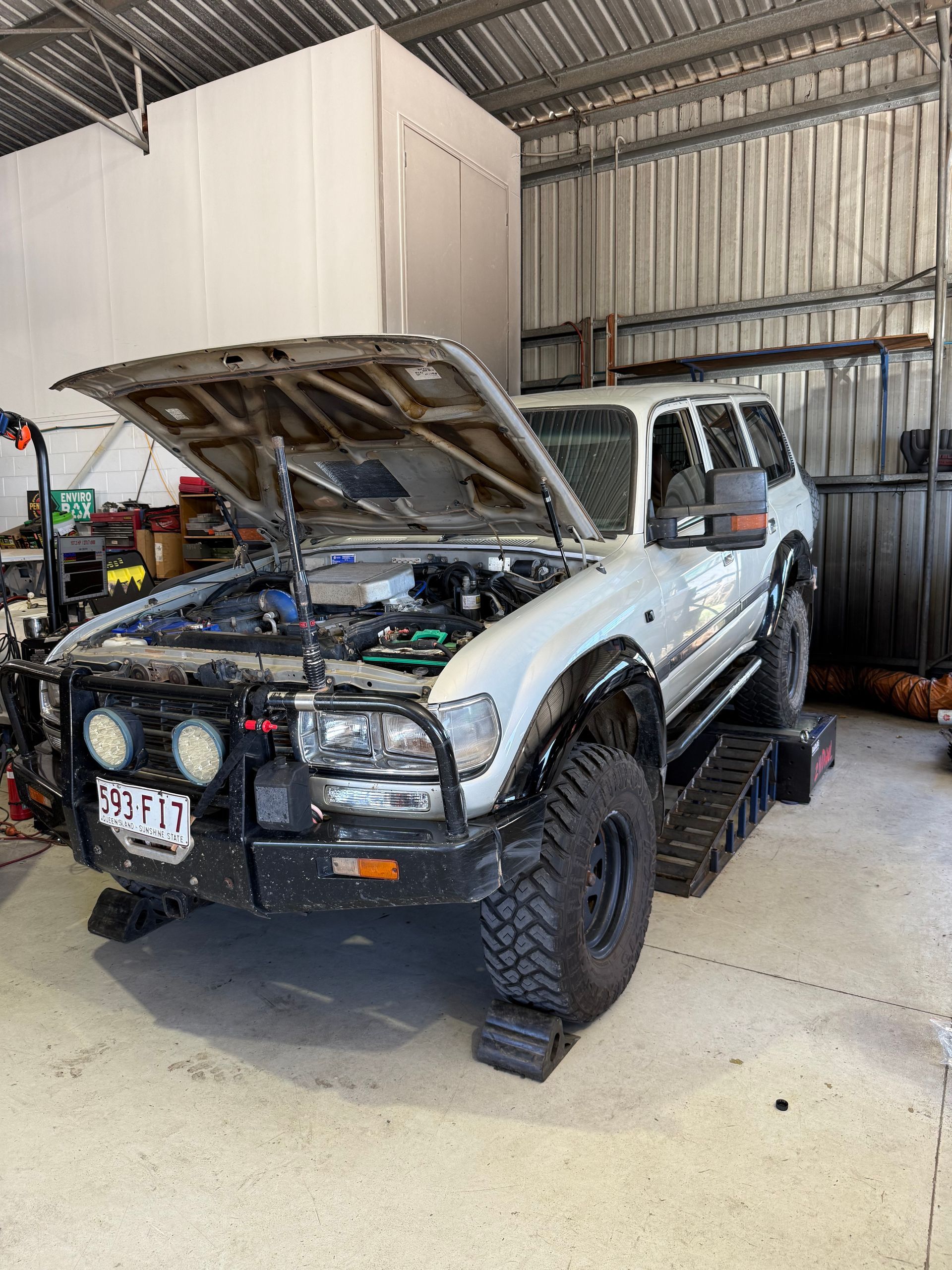White Toyota Land Cruiser with open hood, on ramps, in a workshop — Track N Back 4x4 In Mareeba, QLD