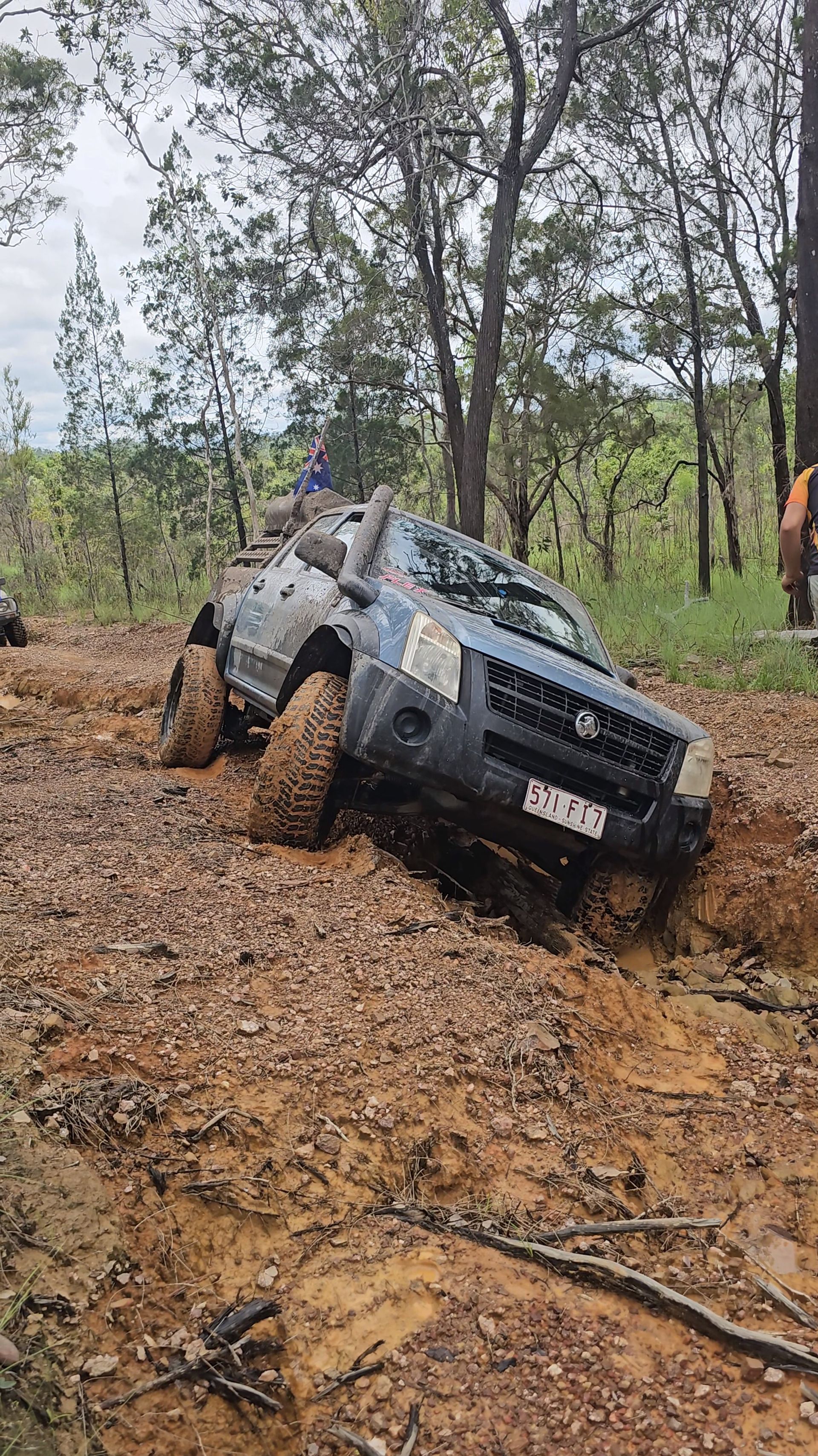 A blue SUV stuck in thick mud on a dirt trail in a forest setting — Track N Back 4x4 In Mareeba, QLD