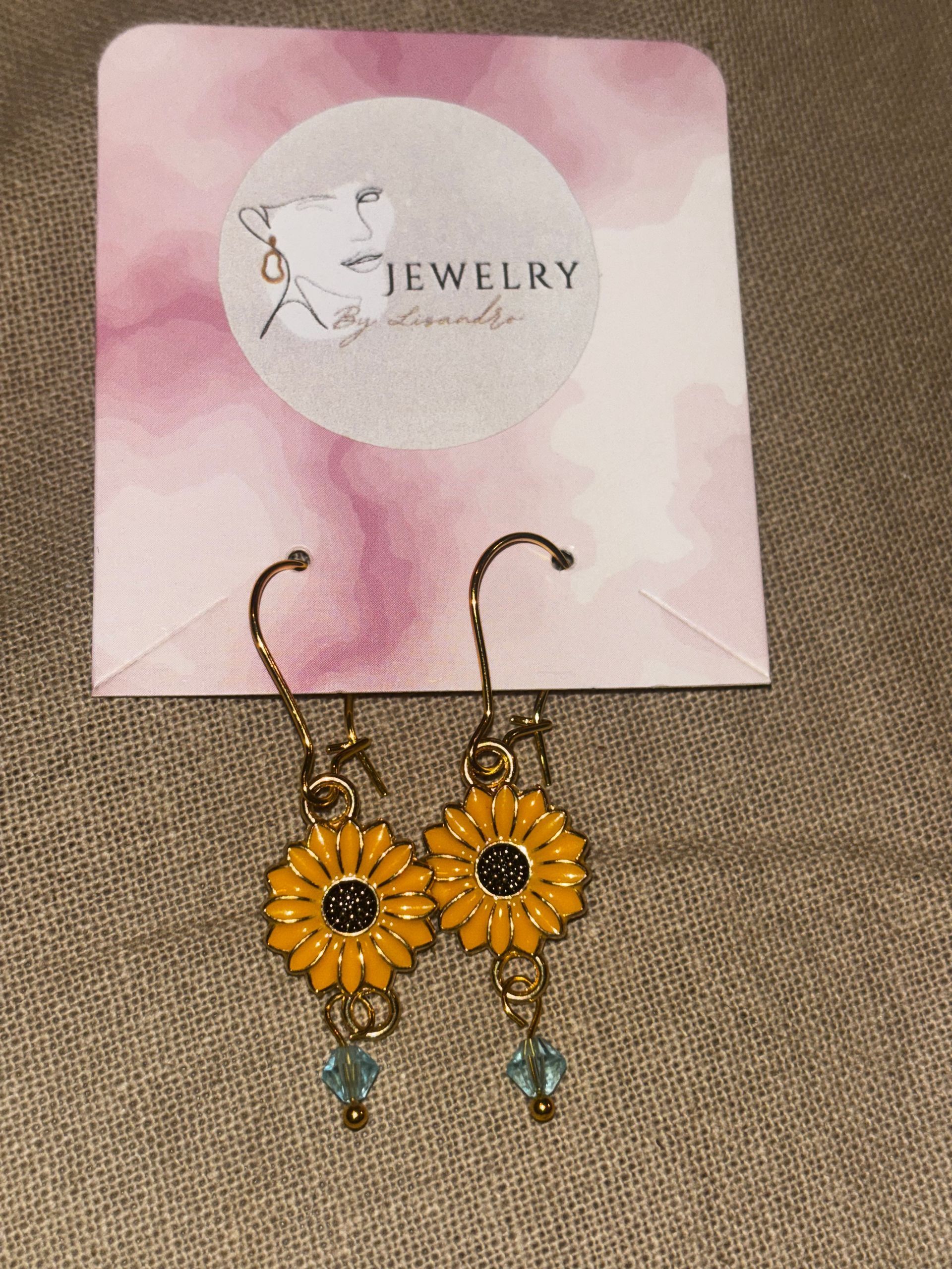 A28 oorbellen goud kleurige bloem met een blauwe steen