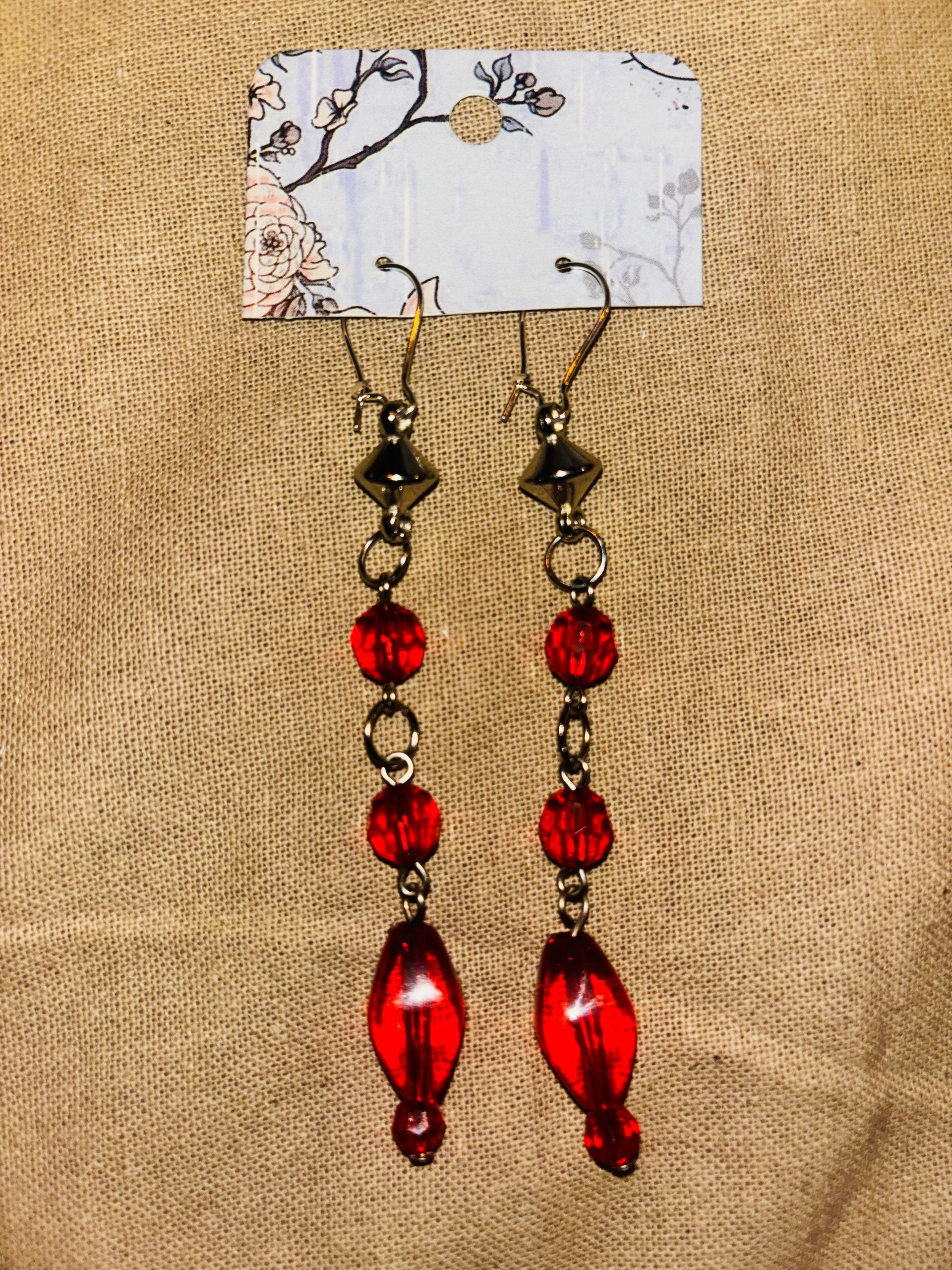 B6. Zilverkleurige hang oorbellen met rode pareltjes