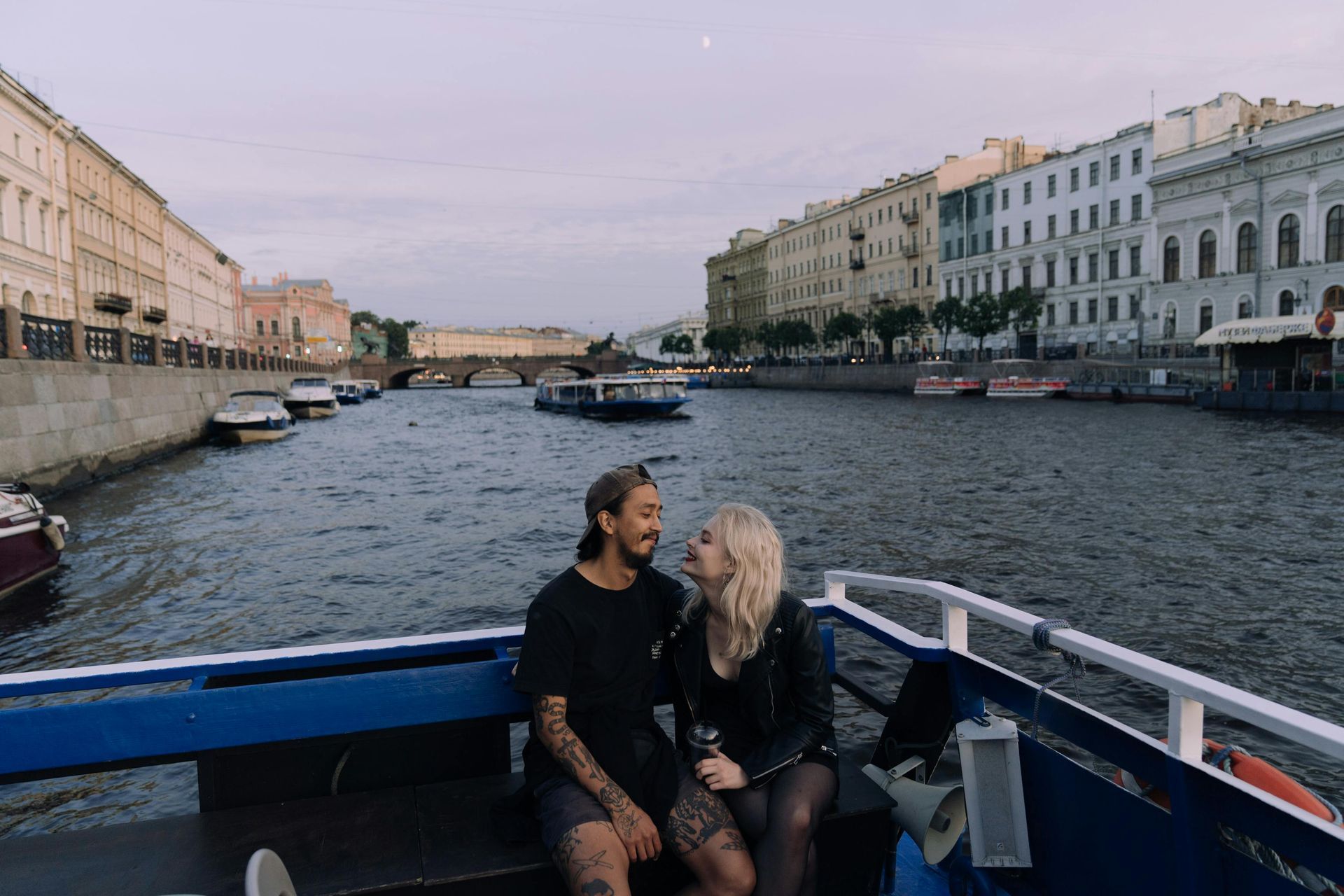 A man and a woman are sitting on a boat looking at each other.