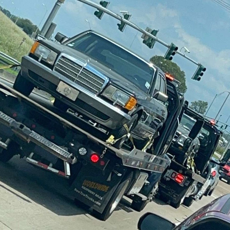A mercedes is being towed by a tow truck