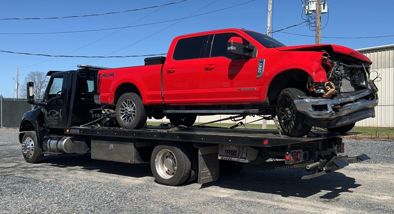 A red truck is sitting on top of a tow truck.