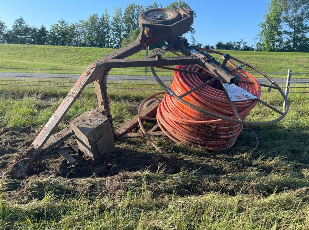 A bunch of wires are laying on the ground in a field.