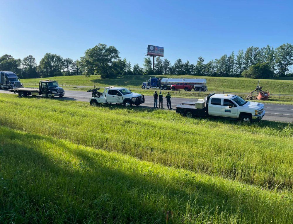 A row of tow trucks are parked on the side of the road.