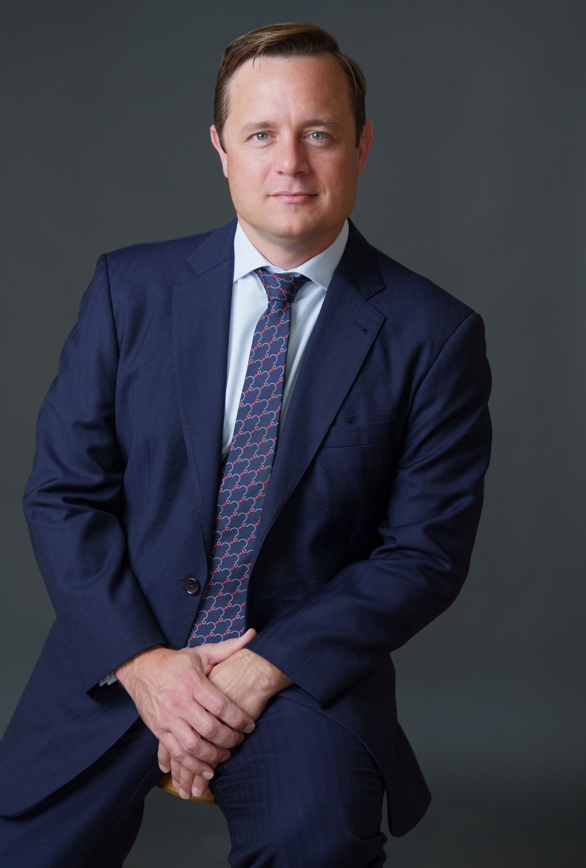 Real Estate, Construction, Property Defect and Damage Attorney Christopher Stow-Serge wearing a dark colored suit, light colored shirt and Hermes tie