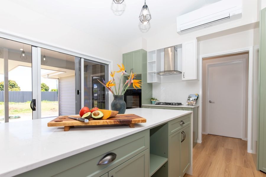 An Empty Living Room With Hardwood Floors and Lots of Windows — Regalline Cabinets & Joinery in Svensson Heights, QLD