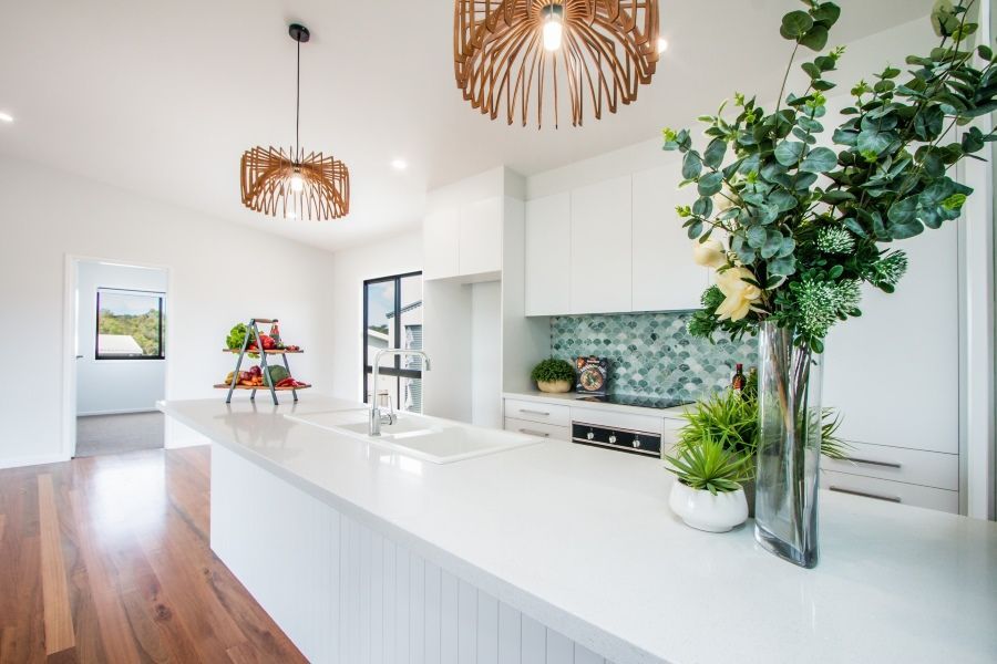 A Kitchen With White Cabinets and a Vase of Flowers on the Counter — Regalline Cabinets & Joinery in Svensson Heights, QLD