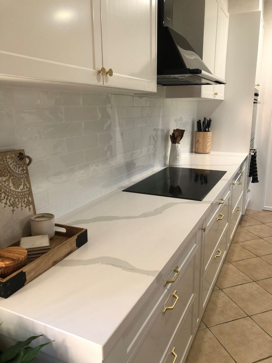 A Kitchen With White Cabinets and a Black Stove Top Oven — Regalline Cabinets & Joinery in Svensson Heights, QLD