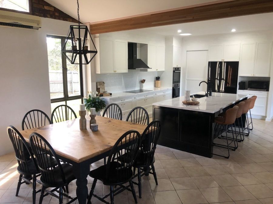 There is a dining table and chairs in the kitchen.