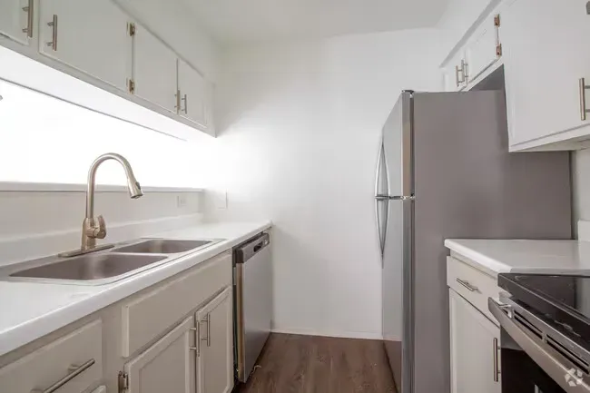 Kitchen with white cabinets, stainless steel appliances, and light countertops.