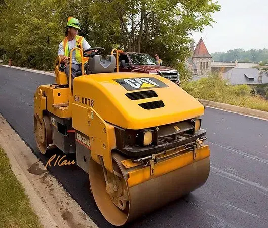A man is driving a yellow cat road roller