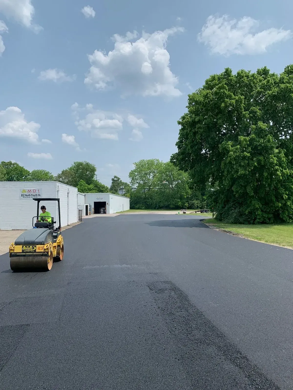 A man is driving a roller on a road.