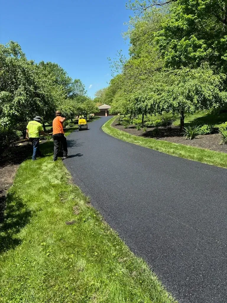 A couple of men standing on the side of a road.