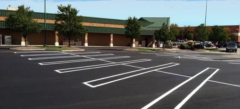 A parking lot with white lines in front of a building