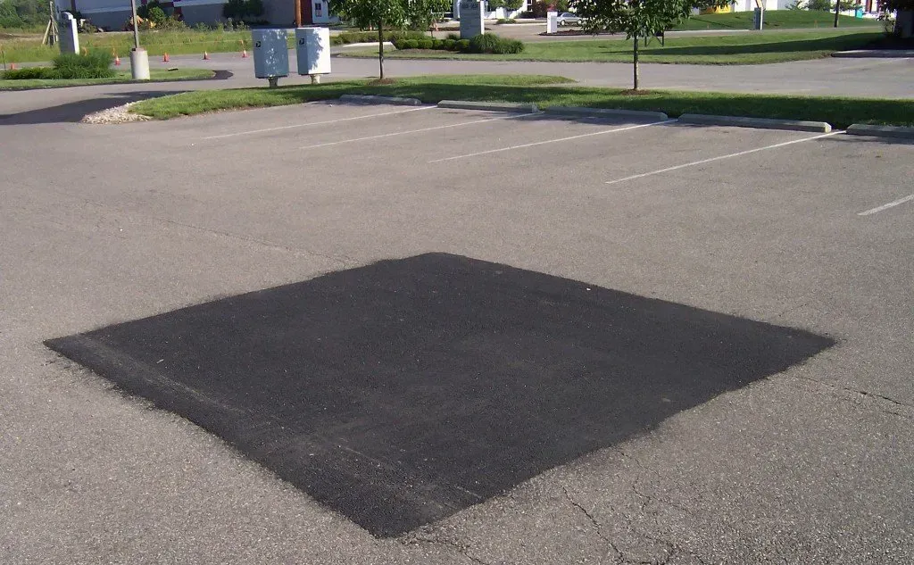 A square patch of asphalt in a parking lot