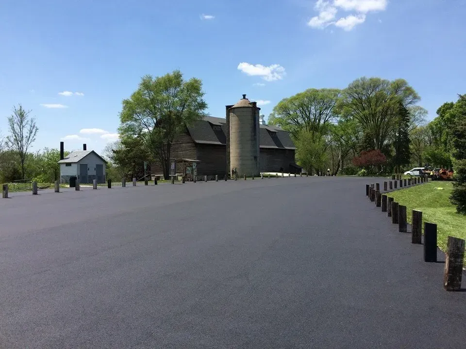 A driveway with a silo and a house in the background