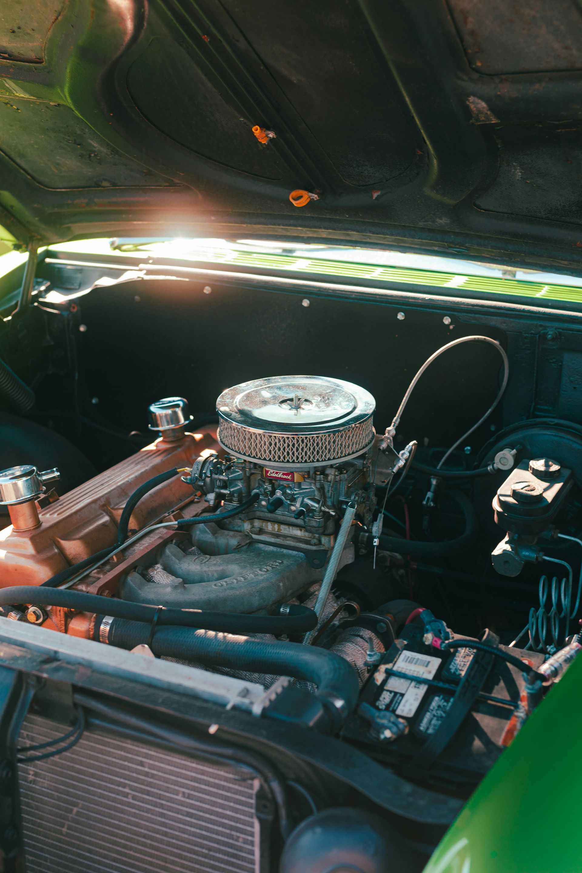 Man in a workshop inspecting a braided hose, looking intently.