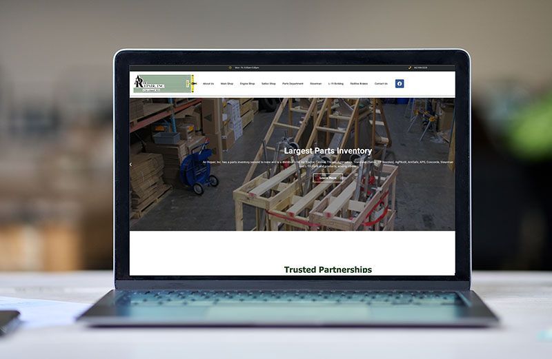 A laptop computer is open to a website on a table.