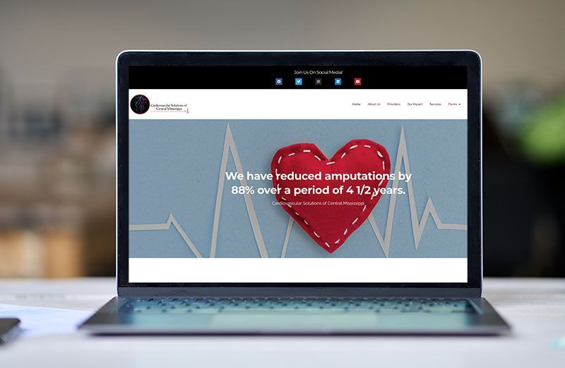 A laptop computer is sitting on a table with a heart on the screen.