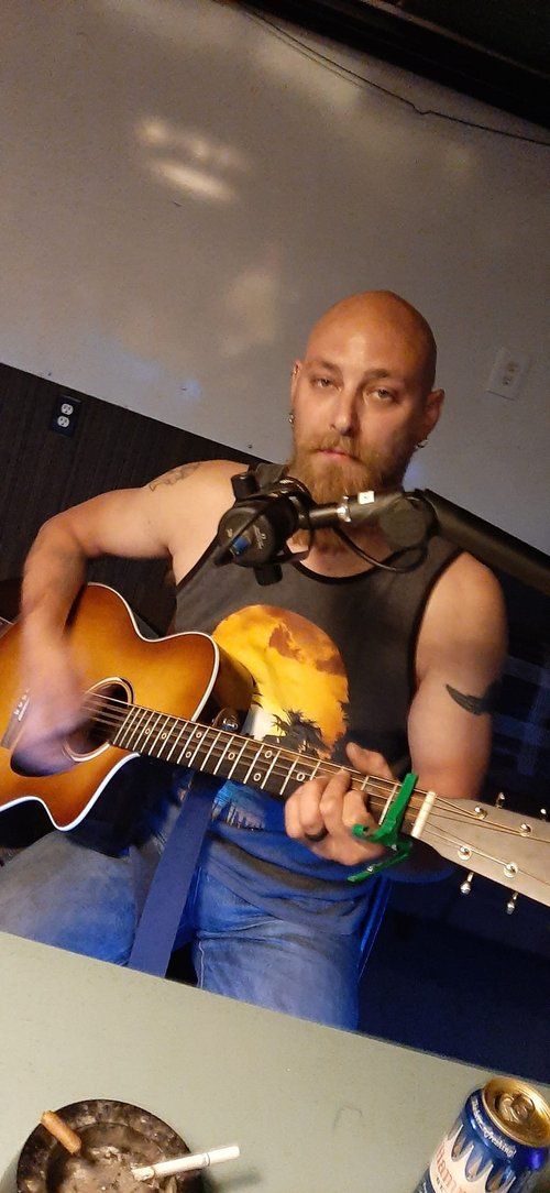 A man is playing a guitar and singing into a microphone