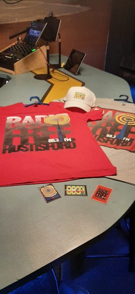 A red t-shirt and a white hat are sitting on a table.
