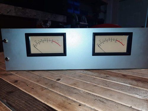 Two meters are sitting on a wooden table.