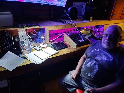 A man is sitting at a desk in a dark room.