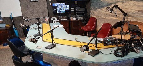 A room with a table and chairs and microphones on it.
