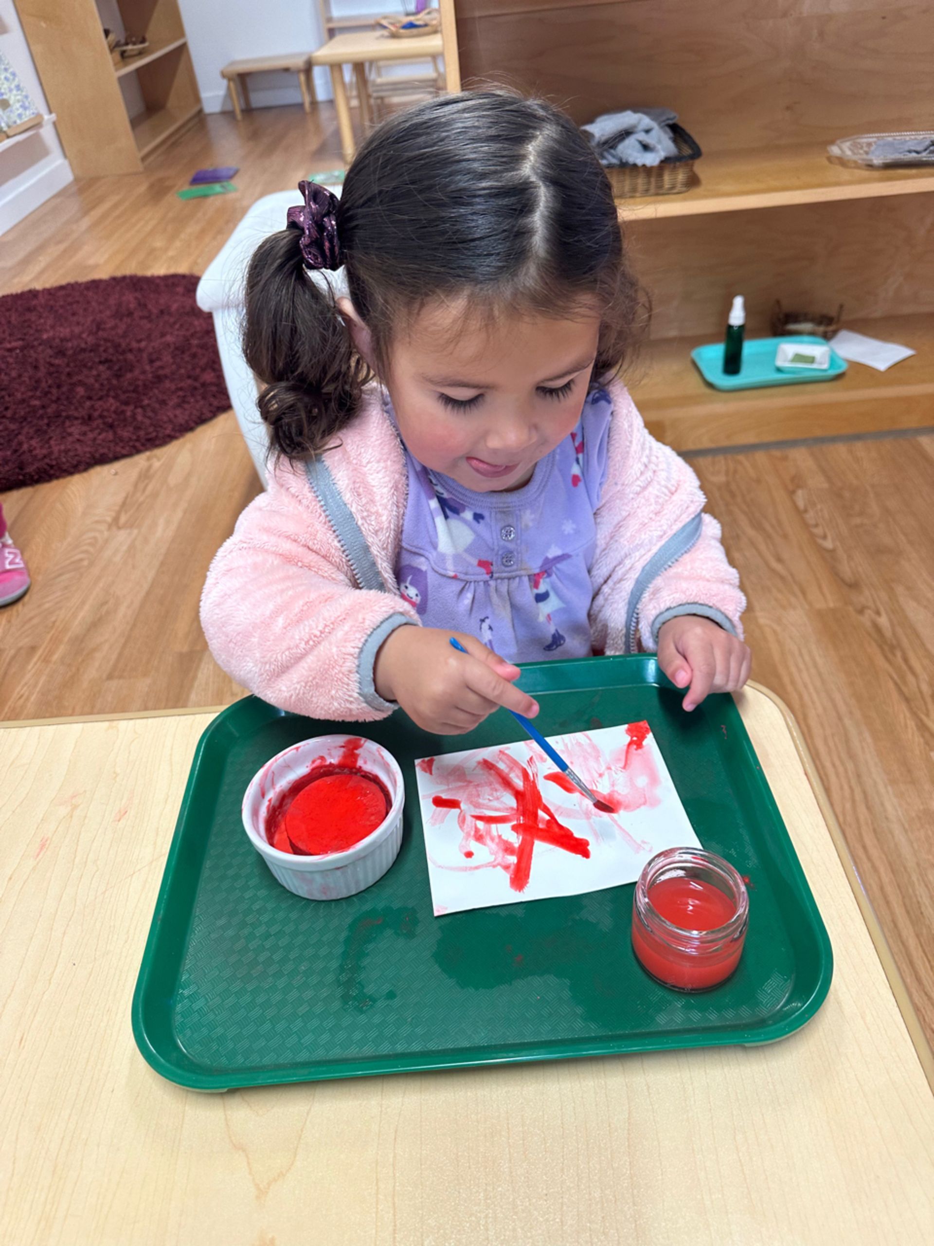 Montessori toddler painting in the classroom